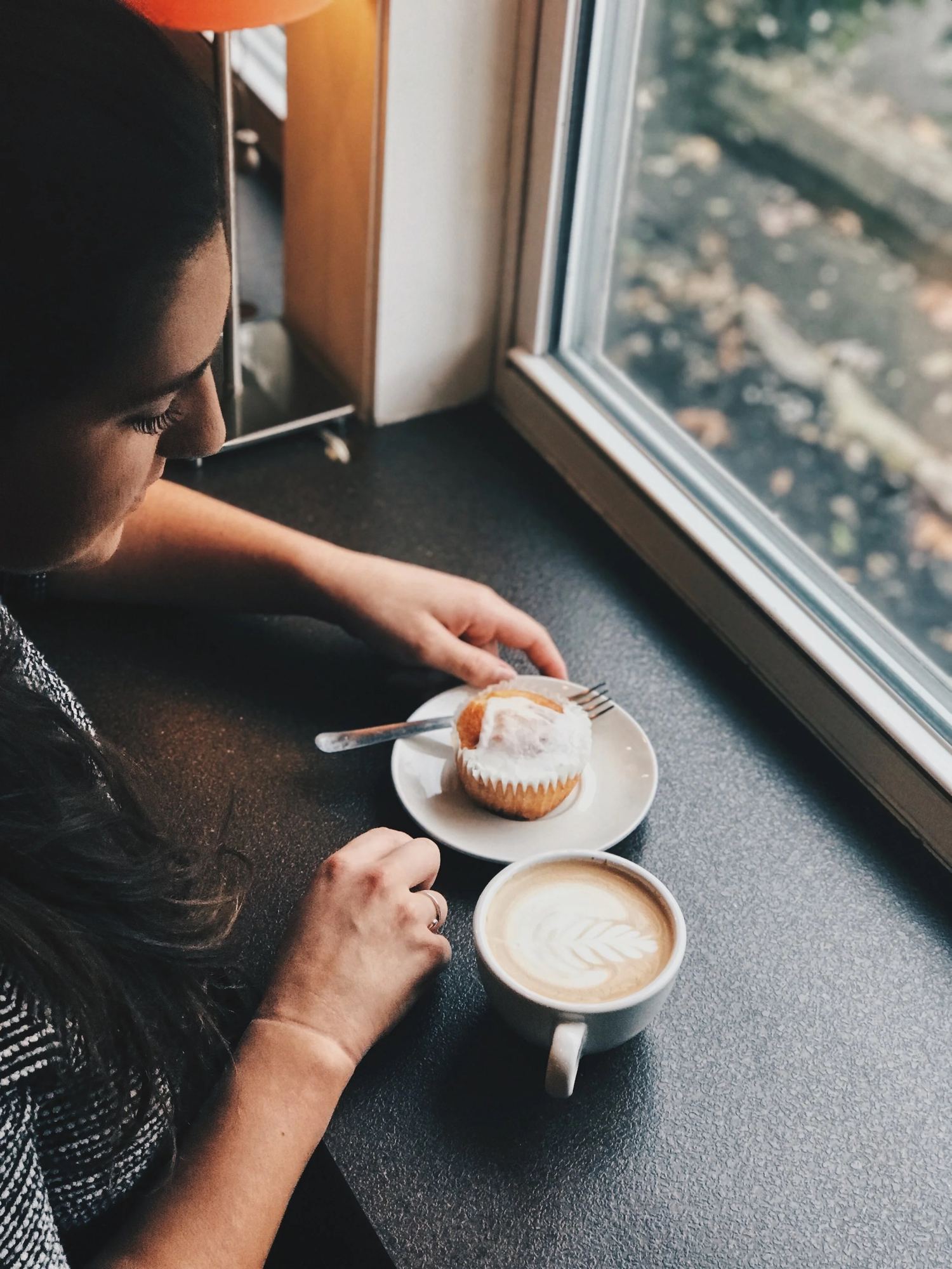 A regular at the window table with a latte and a pastry